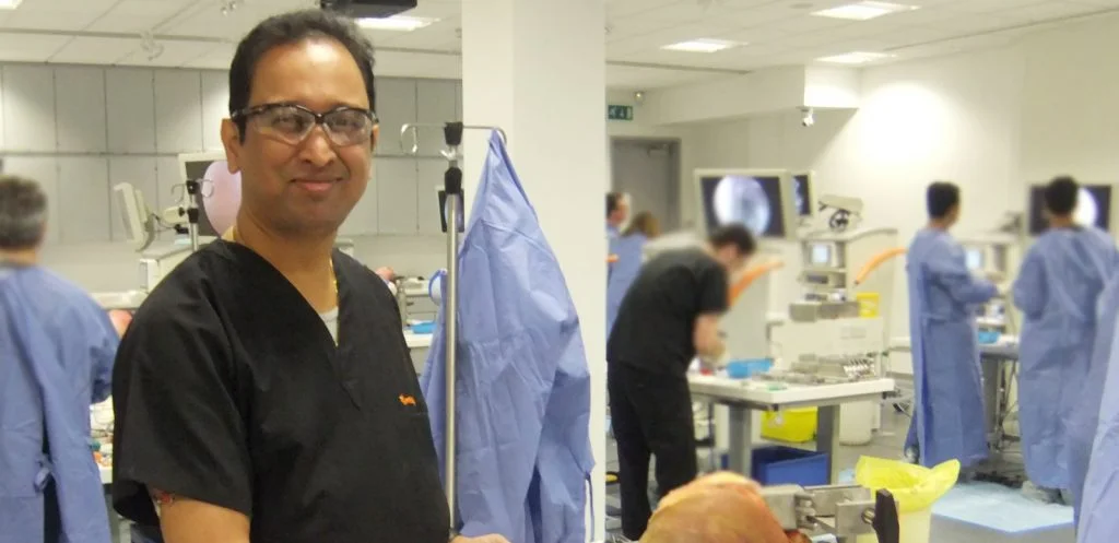 Dr Debnath examining a patient's knee in the consulting room